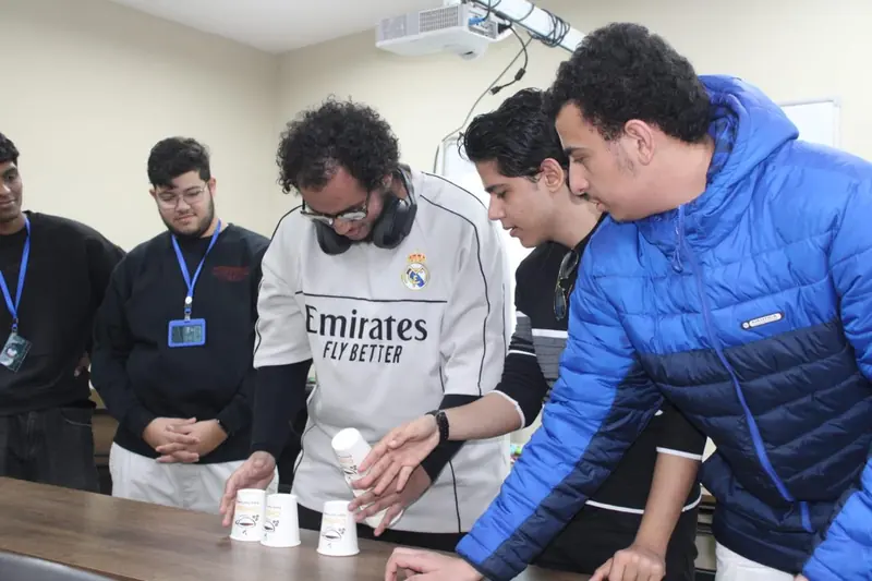 A group of participants leans in to finish a cup challenge
